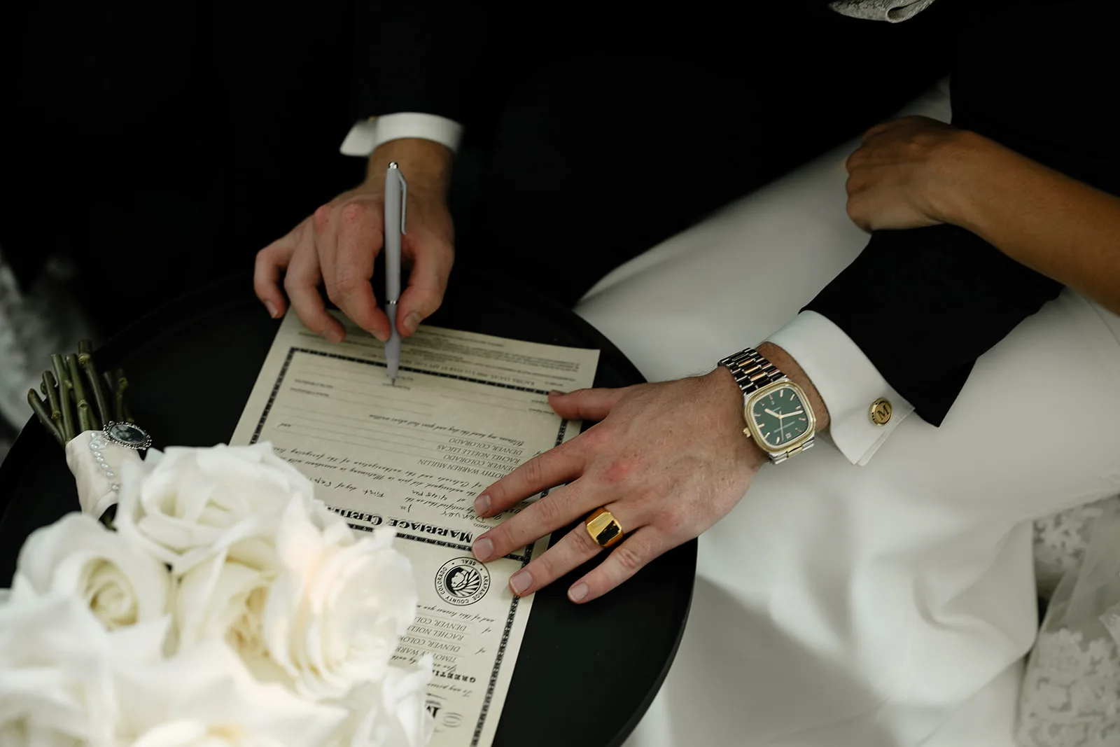 Details shot of bride and groom signing the marriage license
