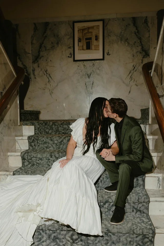 Melanee and Reagan kissing on the stairs of Hotel Teatro